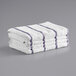 A stack of white towels with purple stripes.