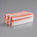 A stack of Monarch Brands coral red striped pool towels.