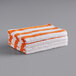A stack of orange and white striped Monarch Brands pool towels.