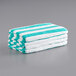 A stack of Monarch Brands green striped pool towels.