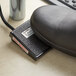 A black foot pedal with a label on it.