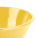 A close-up of a yellow Thunder Group melamine salad bowl.