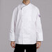 A man wearing a white Chef Revival executive chef coat with black piping.