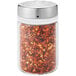 An OXO glass shaker with chili pepper flakes and a stainless steel top.