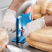 A person using a Lavex Bag Sealing Tape dispenser to seal a bag of bread.