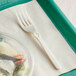 A WeGo Natural Compostable CPLA fork on a white surface.
