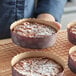 A person holding a tray of baked pies in Novacart kraft paper baking molds.