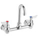 A silver Waterloo wall mount faucet with red and blue knobs.