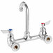A chrome Waterloo wall mount faucet with silver and red and blue knobs.