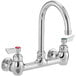 A chrome Waterloo wall mount faucet with two silver handles and 6" gooseneck spout.