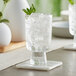 An Acopa Pangea goblet with ice and mint on a table.