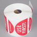 A roll of paper with red and white stickers that says "Use First" with a white background.