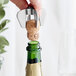 A silver Vacu Vin champagne opener using a corkscrew to open a bottle of champagne.