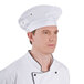 A man in a Chef Revival uniform wearing a white chef beret.
