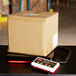 A cardboard box on a Rubbermaid digital receiving scale.