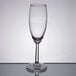 A close-up of a clear Libbey Napa Country flute wine glass on a reflective surface.