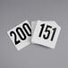 A stack of American Metalcraft plastic table number cards with white numbers on a gray surface.