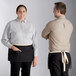A man and woman wearing Acopa Kennett black denim waist aprons with natural webbing.