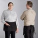 A man and woman wearing Acopa black denim waist aprons with black webbing.