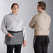 A man and woman wearing Acopa Kennett gray denim waist aprons with black webbing.
