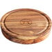 An Outset wood glass rimmer with a circular design on a wooden cutting board.