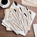 A group of Acopa Inspira stainless steel salad/dessert forks on a table.