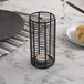 A Sterno black wire metal candle holder on a table.