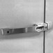 The stainless steel door handle on a white wall.