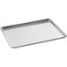 A Choice aluminum wire-in-rim bun and sheet pan on a counter.