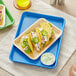 A Baker's Mark light blue aluminum tray with tacos topped with vegetables and jalapenos.