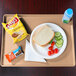A Cambro dark peach dietary tray with a sandwich, vegetables, and a drink on it.