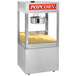 A Cretors floor model popcorn machine with a large container of popcorn inside.