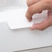 A hand opening a white 10" x 10" x 5" window cupcake box with a white reversible insert.