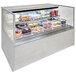 A Structural Concepts Reveal refrigerated self-service display case full of cakes and pastries.