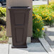 A black rectangular Mayne Fairfield decorative waste bin on an outdoor patio.