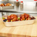 A Vollrath aluminum roasting pan filled with cooked chicken and vegetables on a table.