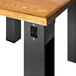 A wooden table with a BFM Seating black steel I-Beam table base with black legs and a black square outlet.