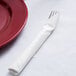 A fork and knife on a Hoffmaster white linen-feel napkin.