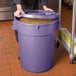 A woman holds a purple round ingredient storage bin with a lid.