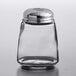 A Tablecraft clear glass cheese shaker with a chrome plated slotted top.