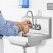 A person using a Steelton wall mounted hand sink with a gooseneck faucet.