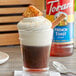 A glass of coffee with Torani French Toast flavoring syrup and whipped cream on top.