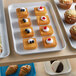 A white Cambro market tray of pastries and muffins.