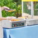 A woman using a Carnival King hot dog roller grill to cook hot dogs.
