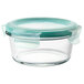 A clear round glass container with a green lid.