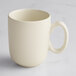 A close-up of an Acopa Pangea fog white matte porcelain cup with a handle.
