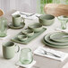 A table set with sage green Acopa Pangea cups and saucers.