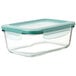 A clear rectangular glass container with a green leakproof lid.