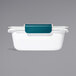 An OXO white food container with a blue lid.