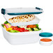An OXO white food container with grilled chicken and salad in it.